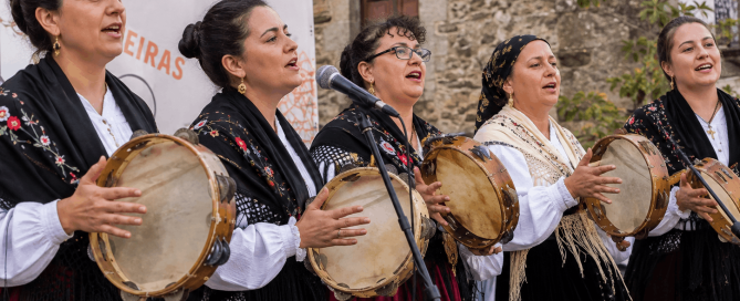 Grupo de pandeireteiras interpretando música tradicional gallega con panderetas durante una actuación popular