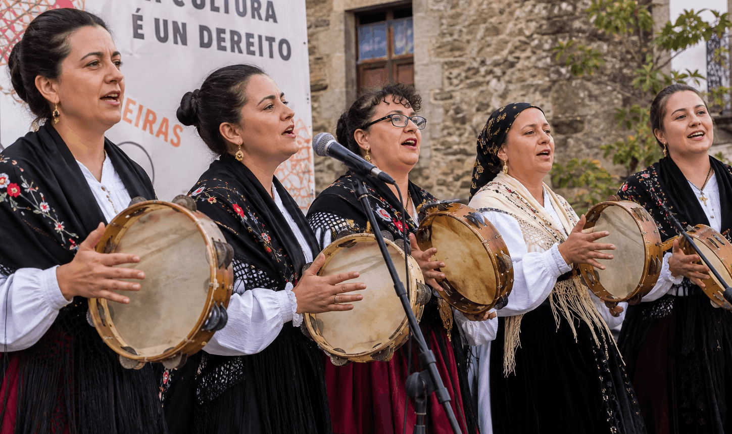Grupo de pandeireteiras interpretando música tradicional gallega con panderetas durante una actuación popular
